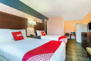 two beds in a hotel room with red pillows at OYO Hotel Myrtle Beach Kings Hwy in Myrtle Beach +16 photos