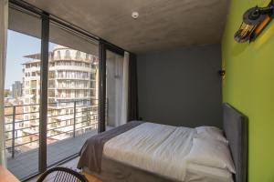 a bedroom with a bed and a large window at Hotel CH51 in Batumi