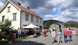 a group of people walking down a street next to a building at Leiligheten in Fyresdal