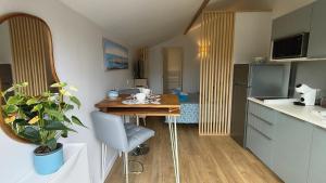 安德诺莱斯贝恩Le "Refuge du Marin" confort et calme pour 2 personnes的一间带桌子的小厨房和一间餐厅