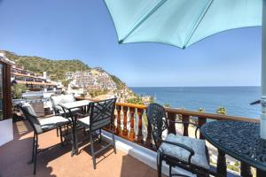 a balcony with chairs and tables and the ocean at H159 - Hamilton Cove Villa 1-59 in Avalon