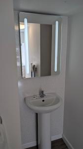 a bathroom with a white sink and a mirror at Duke of Cornwall in St Austell +5 photos