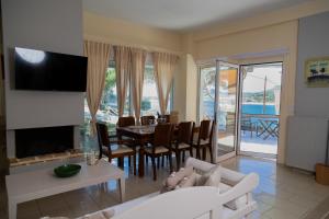 a living room with a dining room table with a view of the ocean at Poseidon Apartments and Villas by the Sea in Sounio