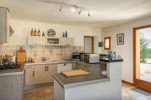 a kitchen with white cabinets and a counter top at Gîte de Caillou in Berbiguières +14 photos