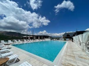 a large swimming pool with chairs and a blue sky at Balandda Chimgan in Chimgan