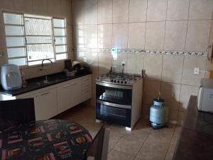 a small kitchen with a stove and a sink at Casa de Fundo da Martinha in Campinas