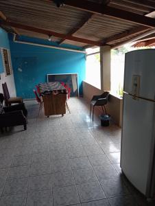 a living room with a table and a refrigerator at Casa de Fundo da Martinha in Campinas