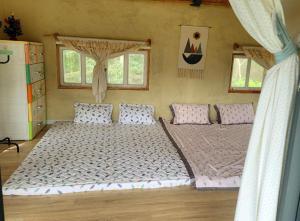 a bedroom with two beds and two windows at Suoirao Chau Duc Green Retreat in Ấp Quảng Giáo