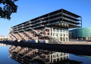 a building with a reflection in a body of water at Appartement Vue Canal in Strasbourg