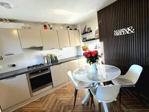 a kitchen with a table with a vase of flowers on it at Modern Duplex in Greystones in Na Clocha Liatha +20 photos