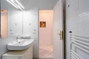 un bagno bianco con lavandino e specchio di Vanna's House a Firenze Altre 42 foto
