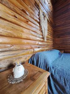 a bedroom with a bed and a wooden wall at Cabaña La Obsidiana in San Miguel del Monte