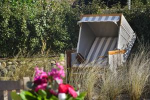 an open refrigerator sitting in a field with flowers at Haus Lang Libben in Archsum