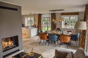 a living room with a dining table and a fireplace at Haus Lang Libben in Archsum +45 photos