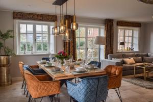 a dining room with a table and chairs and a couch at Haus Lang Libben in Archsum
