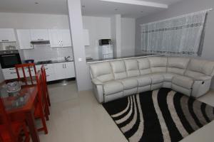 Una sala de estar con un sofá blanco y una cocina. en Villa Racine, en Porto Novo