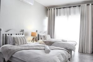 a bedroom with three beds and a window at Riverview 2 #1 Self-catering accommodation in Swakopmund +26 photos