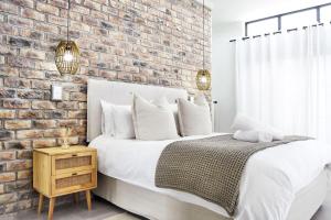 Un dormitorio con una pared de ladrillo y una cama. en Riverview 2 #1 Self-catering accommodation, en Swakopmund