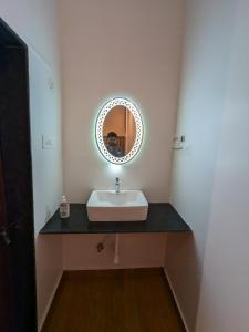 a bathroom with a sink and a mirror at CharDara Agrotourism & FarmStay in Mahabaleshwar