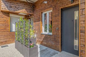 a wooden house with a black door and some plants at Vienne in Lyon +23 photos