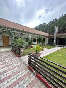 a building with a fence in front of a yard at Mawa Hotel Balakot in Bisiān