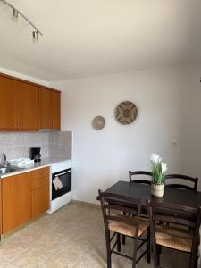 a kitchen with a table and chairs and a counter at Meltemi Beach Apartment in Mochlos