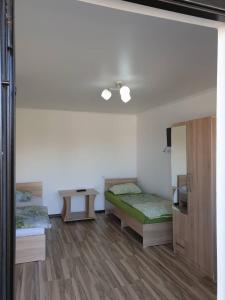 a room with two beds and a table and a mirror at Moonlight in Cholpon-Ata