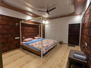 a bedroom with a canopy bed in a brick wall at CharDara Agrotourism & FarmStay in Mahabaleshwar