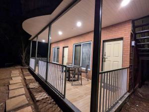 a screened porch with a table and a white door at CharDara Agrotourism & FarmStay in Mahabaleshwar