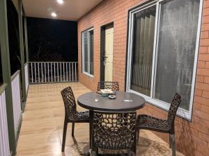 a patio with a table and chairs on a balcony at CharDara Agrotourism & FarmStay in Mahabaleshwar