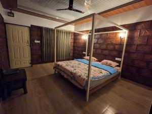 a bedroom with a canopy bed in a room at CharDara Agrotourism & FarmStay in Mahabaleshwar