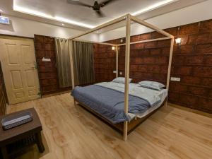 a bedroom with a canopy bed and a table at CharDara Agrotourism & FarmStay in Mahabaleshwar