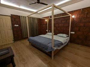 a bedroom with a canopy bed and a piano at CharDara Agrotourism & FarmStay in Mahabaleshwar