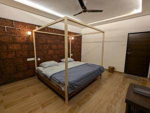a bedroom with a canopy bed and a television at CharDara Agrotourism & FarmStay in Mahabaleshwar