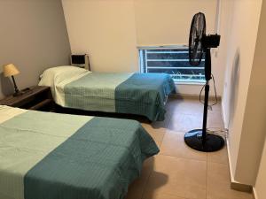 En eller flere senge i et værelse på Depto Costanera