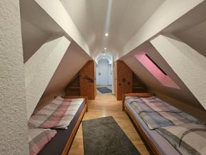 a attic bedroom with two beds in a room at Fewo-O3-4-6-Personen-23km-bis-Frankfurt-Nord in Ober-Mörlen