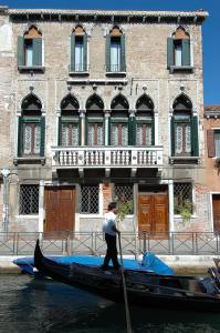 Un uomo in una gondola di fronte a un edificio di Palazzo Odoni a Venezia