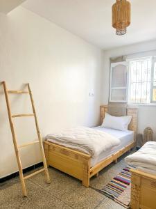 a bedroom with a bed and a ladder in it at Surf and Stay Anza - Surf Territory in Agadir