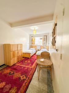 a living room with two beds and a table at Surf and Stay Anza - Surf Territory in Agadir