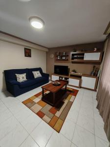 a living room with a blue couch and a table at La casa del Rubio in Pedreña