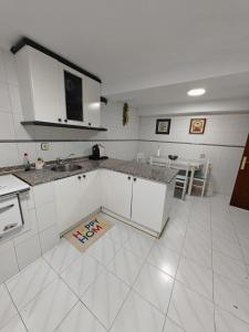 a white kitchen with a sink and a counter at La casa del Rubio in Pedreña +6 photos