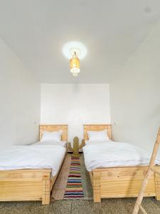 two beds sitting next to each other in a room at Surf and Stay Anza - Surf Territory in Agadir