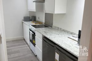 Una cocina con gabinetes blancos y encimera. en OnSiteStays - 4 bedroom house with 2 bathrooms, en Welling 21 fotos más