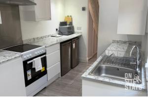 una cocina con fregadero y estufa en OnSiteStays - 4 bedroom house with 2 bathrooms, en Welling