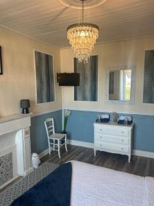 a bedroom with a bed and a desk and a chandelier at The LightHouse Chambres à louer in Châteaulin