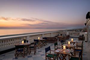 a restaurant with tables and chairs on a balcony at Palace Hotel in Viareggio
