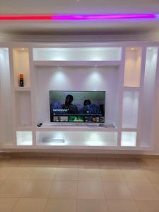 a flat screen tv in a white wall at Rumkin Homes in Lotus Island