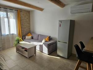a living room with a couch and a refrigerator at LA VASIO Hypercentre Vaison-la-Romaine - Air-conditioned in Vaison-la-Romaine