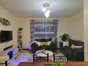 a living room with a couch and a table at Sunbird Serenity Stays in Nairobi