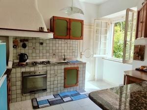 a kitchen with a sink and a stove top oven at AragoniteAzzurra Casa Vacanza in Gonnesa